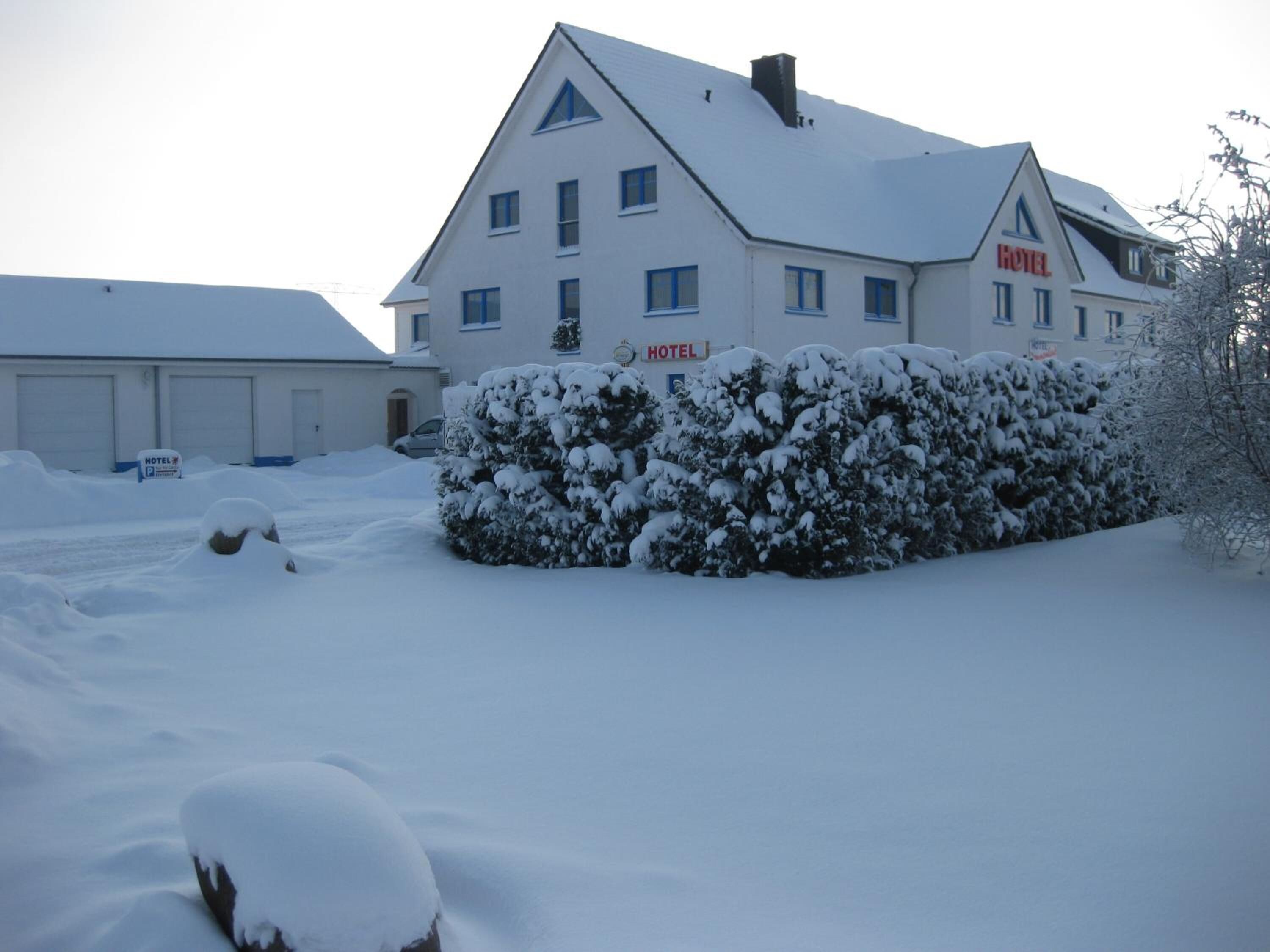 Un hotel con tejado nevado y un cartel que indica que es un hotel.