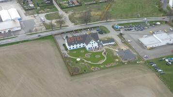 An aerial view of a hotel with a large building labeled "HOTEL" in the center, surrounded by a well-maintained lawn and parking area.