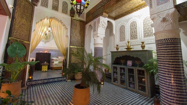 An interior with ornate arches, a checkered floor, and a chandelier. - Riad Sanaa Rose (Fes)