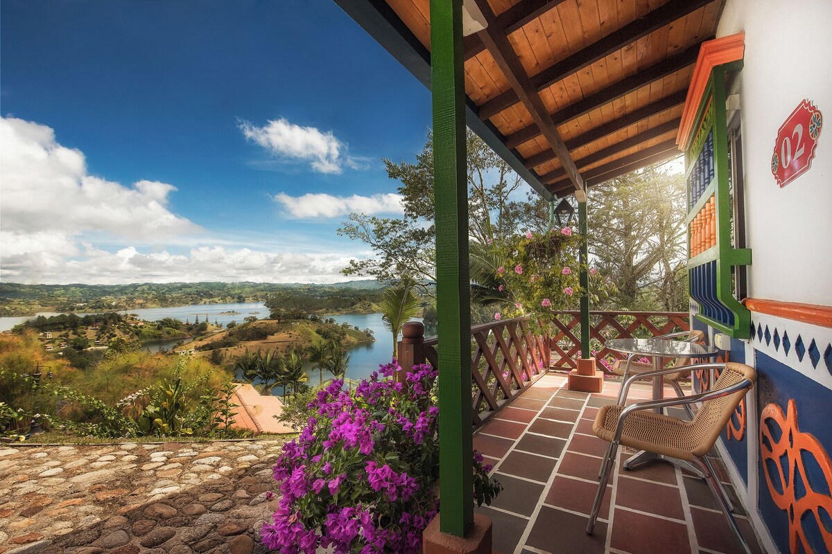 A terrace with a view of a lake, a chair, and a table.