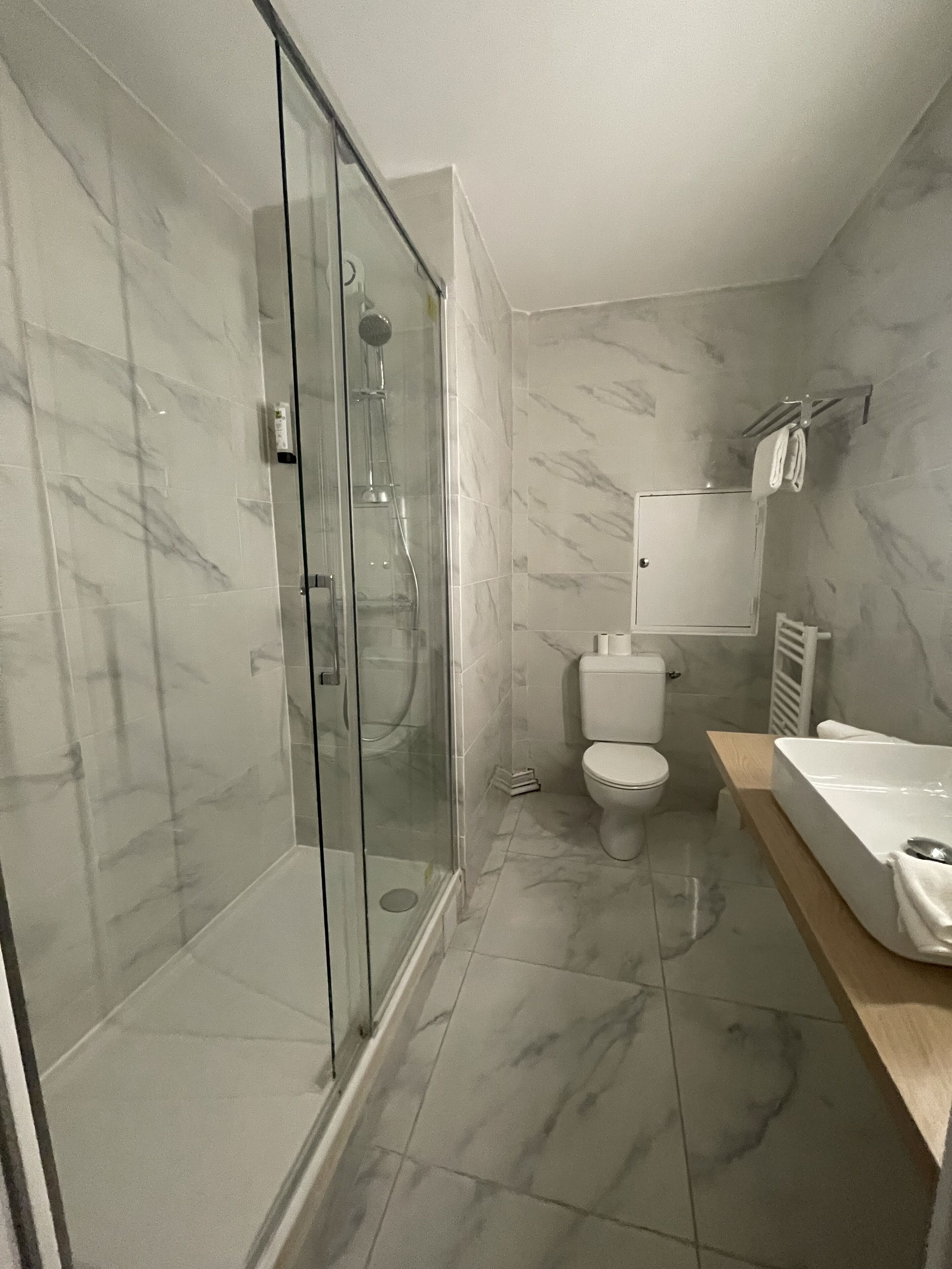 Un baño moderno con ducha envuelta en cristal, inodoro y bañera.
