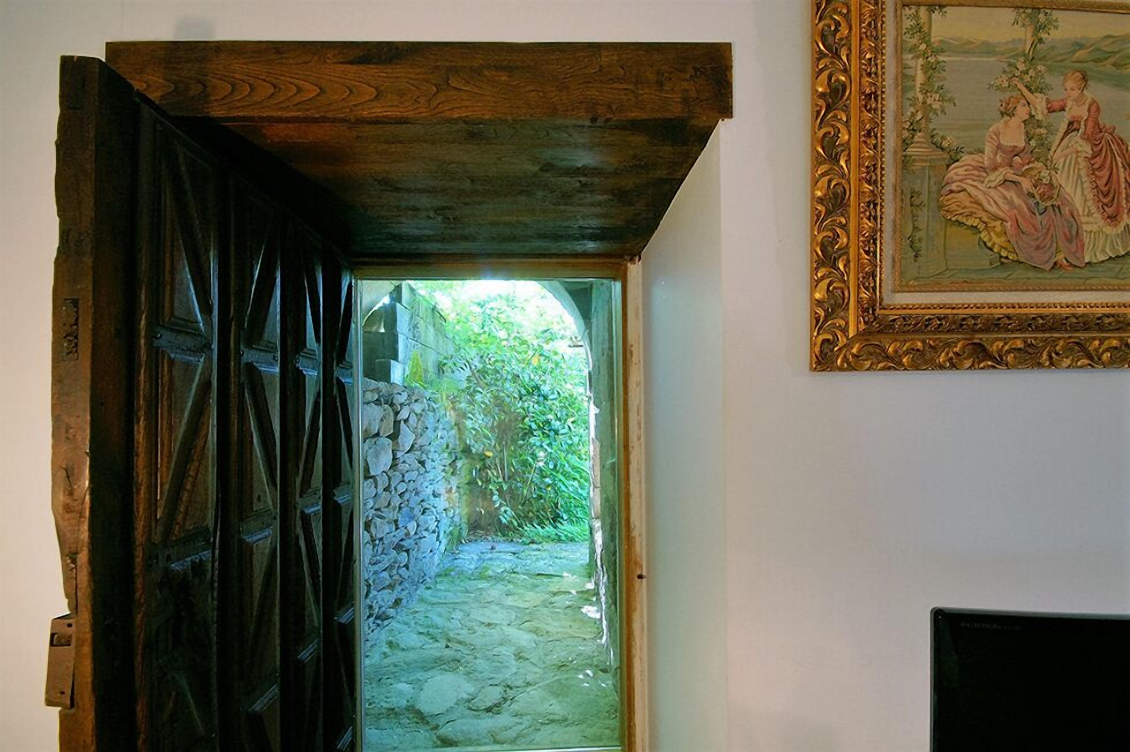 Una puerta de madera rústica que da a un camino de piedra.