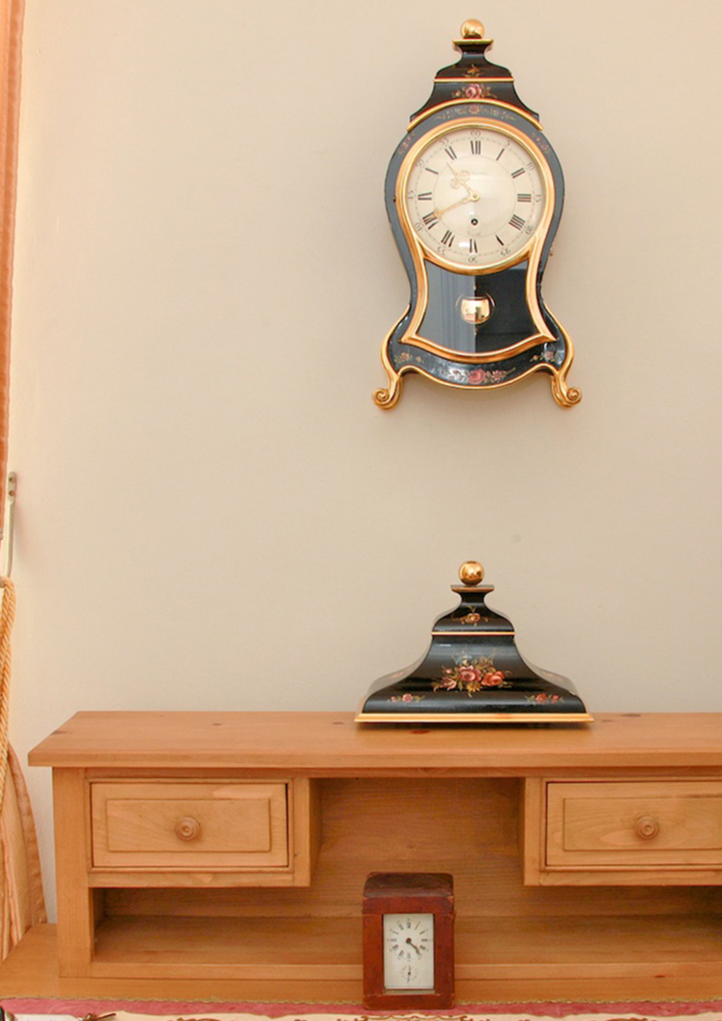 A wooden dresser with two drawers and a small clock on the front.