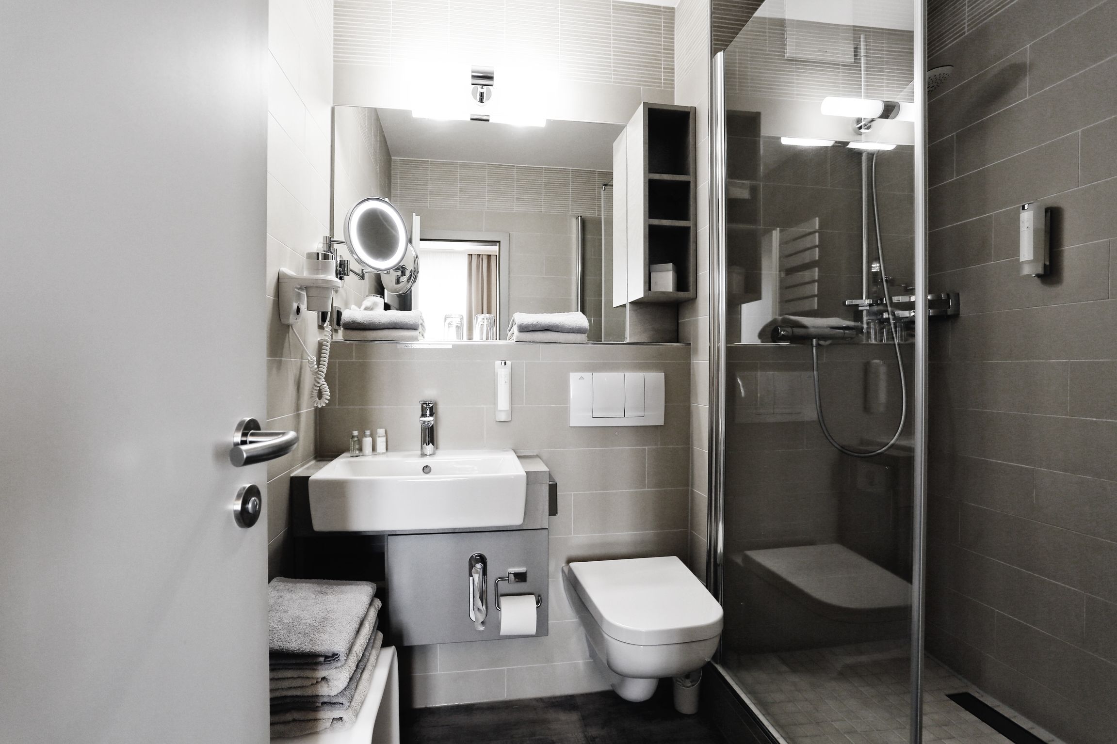 Een moderne badkamer met een wastafel, toilet en douche.