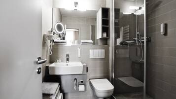 Een moderne badkamer met een wastafel, toilet en douche.