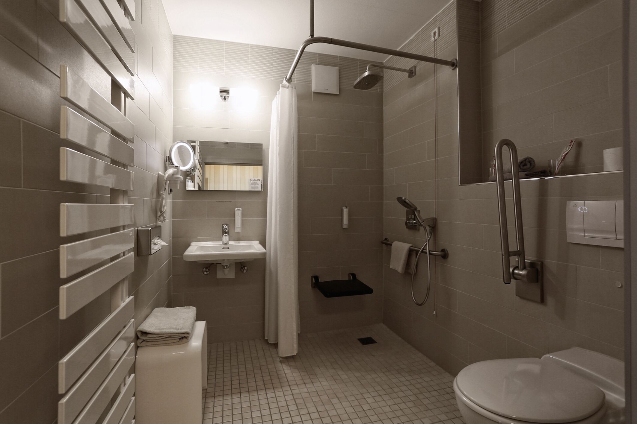 A modern bathroom with a shower, toilet, sink, and vanity.