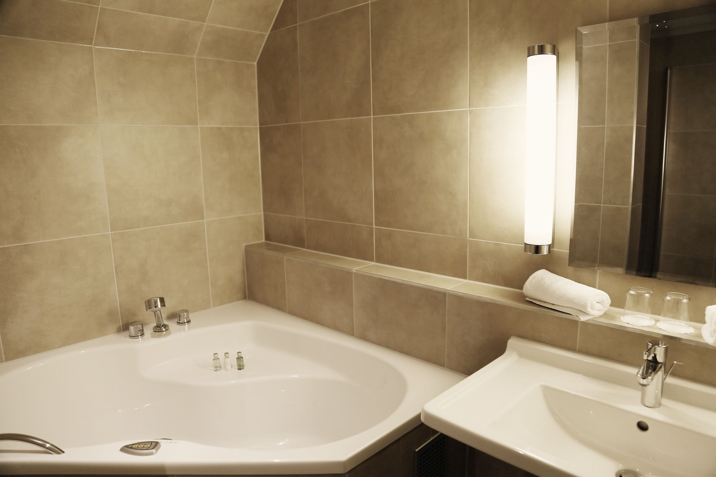 Un baño con bañera, lavabo y espejo.
