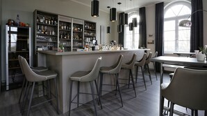 A modern kitchen with a bar area, bar stools, and a large window with curtains.
