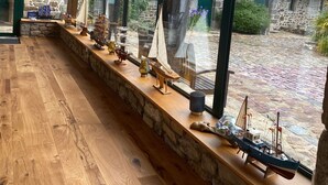 A room with large windows, wooden flooring, and a stone wall. - Manoir de Rigourdaine (Plouer-sur-Rance)