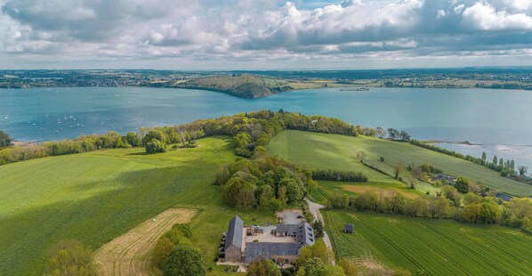 An aerial view of a rural property with a large house surrounded by fields and a lake. - Manoir de Rigourdaine (Plouer-sur-Rance)
