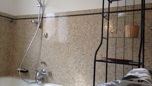 A bathroom with a bathtub, a shower, and a towel rack. - Affittacamere Le Rose (Imola)