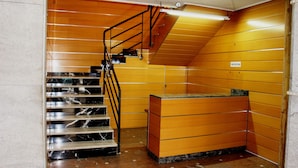 A reception area with a marble staircase and a reception desk. - Hostal Al-Andalus (Granada)