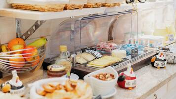 Un buffet proposant une variété de plats, notamment des fruits, des fromages et des pâtisseries.