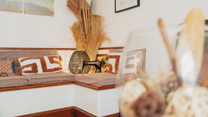 A corner of a room with a wooden bench, a vase with dried plants, and a framed picture on the wall. - Hôtel Quic en Groigne (Saint-Malo)