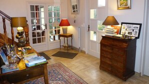 Une pièce confortable avec un bureau en bois, une lampe, un tapis et une commode.