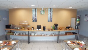 Un bar à petit-déjeuner proposant des machines à café, des services à thé et une variété d'aliments pour le petit-déjeuner.