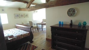 A cozy room with a bed, a dresser, and a chair. There is a window and a door. - Maison Sans Soucis (Sainte-Gemme)