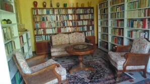 A cozy living room with a sofa set, a coffee table, and a bookshelf filled with books. - Maison Sans Soucis (Sainte-Gemme)