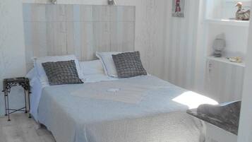 Une chambre avec un grand lit, une table de chevet et une fenêtre.