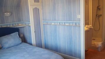 Un dormitorio con cama, armario y zona de ducha.