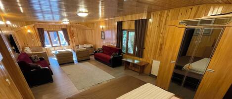 A wooden interior with a bed, a sofa, and a table.