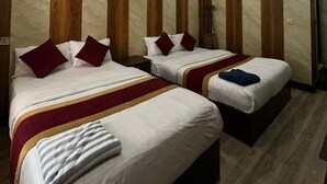 A hotel room with two beds, wooden paneling on the walls, and an air conditioning unit. - Hotel Dine & Dream (Kathmandu)