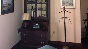 A room with a bed, a dresser, a lamp, and a mirror. There are two framed pictures on the wall. - The Harry Packer Mansion Inn (Jim Thorpe)
