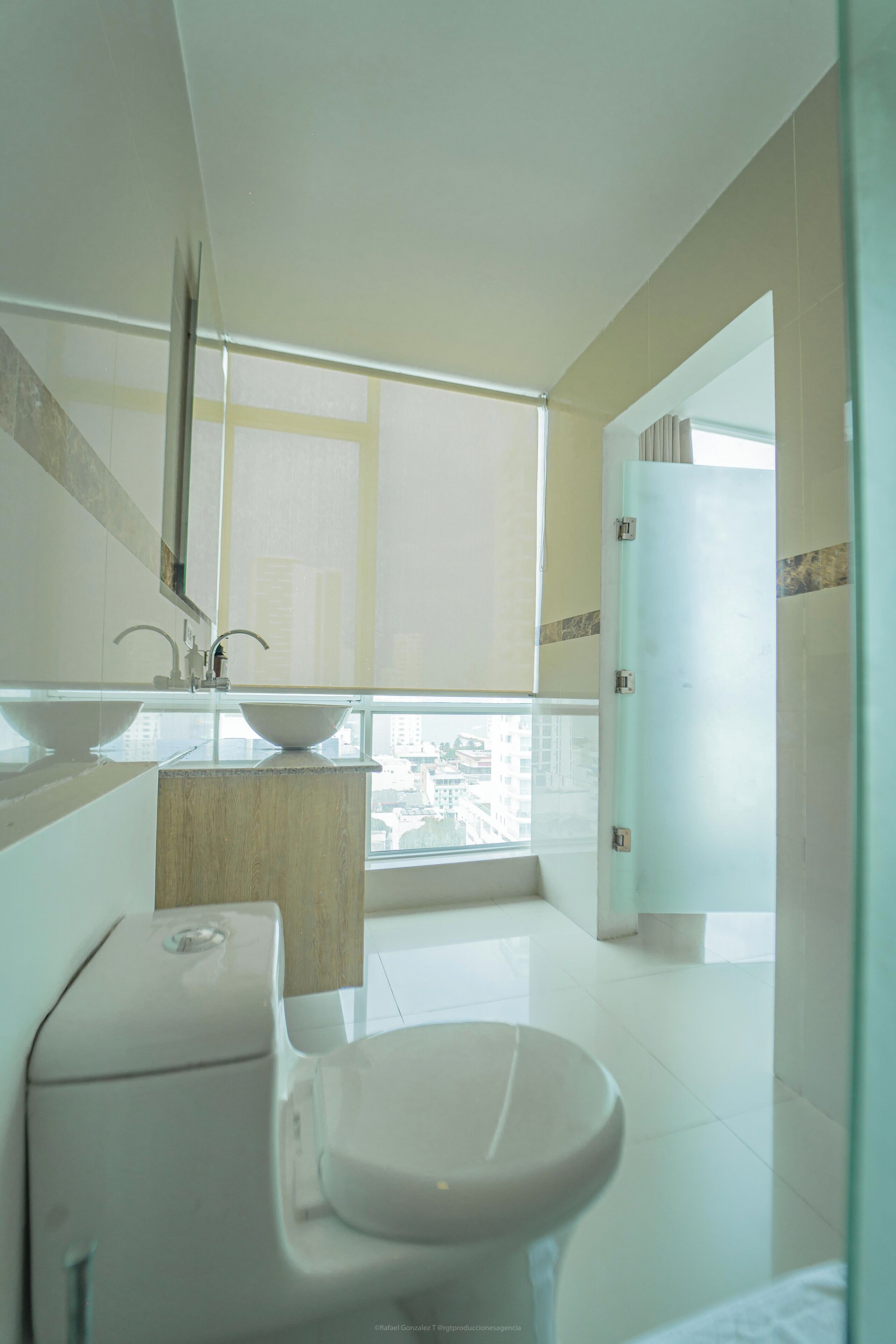 Une salle de bain moderne avec des toilettes, un lavabo et une fenêtre.