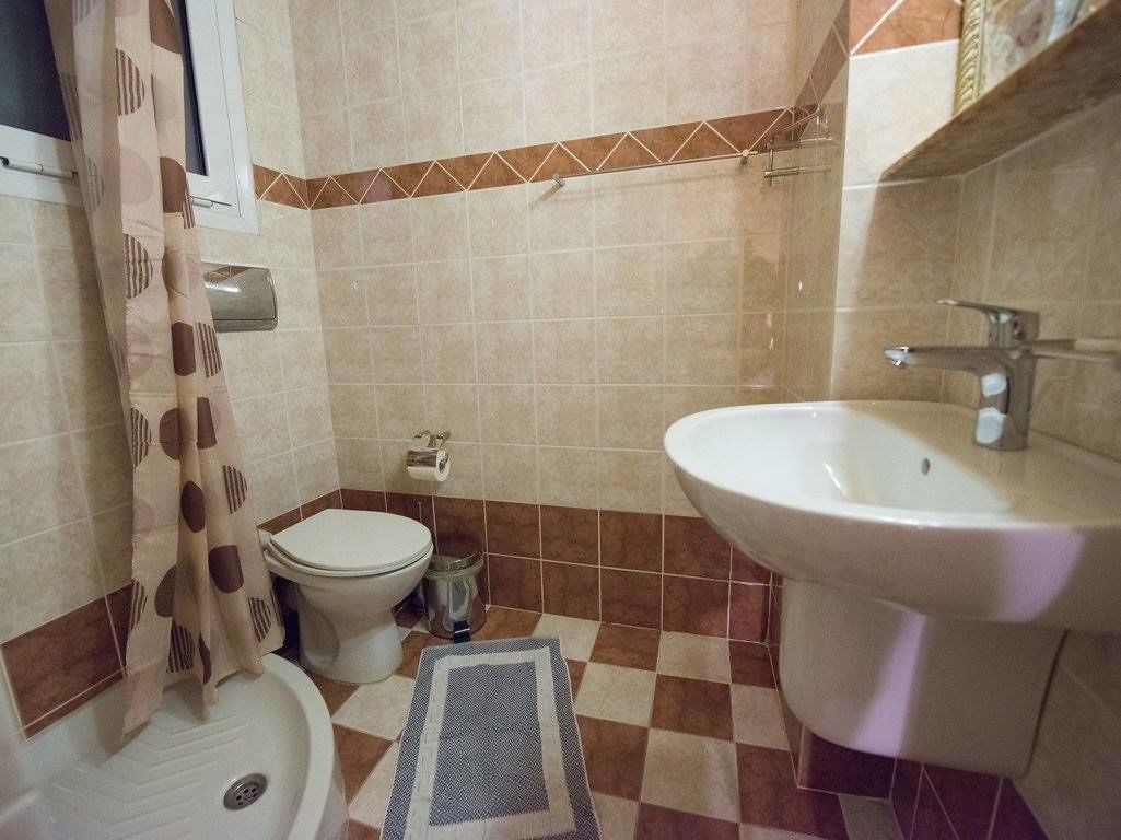 A bathroom with a toilet, sink, and shower.
