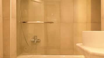 Um banheiro moderno com banheira, vaso sanitário e área de chuveiro.