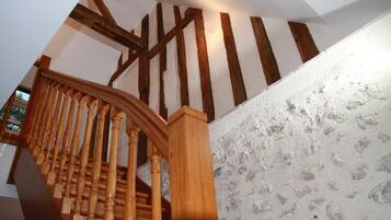 Een houten trap met zichtbare balken en een structuurwand.