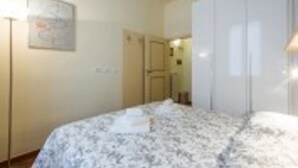 Un dormitorio con cama, armario y puerta.
