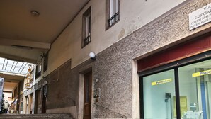 Un bâtiment doté d’un escalier menant à l’entrée, d’une enseigne indiquant un service postal et d’une fenêtre ornée d’une rambarde en métal.