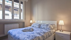 Une chambre à coucher avec un lit, des tables de chevet et une fenêtre.