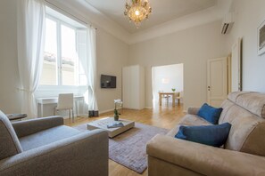 Una sala de estar moderna con sofá, sillón, mesa de centro y comedor con mesa y sillas.