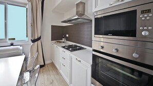 A modern kitchen with a gas stove, built-in oven, and microwave. - Borgo dei Greci (Florence)