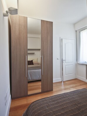A bedroom with a wardrobe, a bed, and a door. - Brunelleschi (Florence)