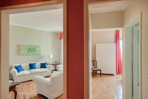 A living room with a white sofa, a coffee table, and a painting on the wall. - Carolina (Florence)