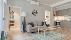 Una sala de estar moderna con sofá, mesa de centro y un reloj en la pared.