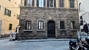 A multi-story building with a stone facade and a black door. - Ghibellina Michelangelo (Florence)