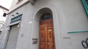 A wooden door with a metal handle, a mail slot, and a small window above it. - Liberta Loft (Florence)
