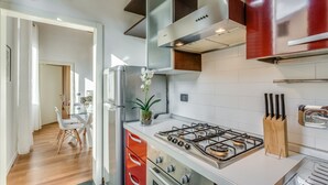 A modern kitchen with stainless steel appliances, a gas stove, and a knife block. - Luna Chic (Florence)