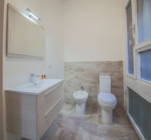 A bathroom with a sink, mirror, toilet, and bidet. - Malenchini Vasari (Florence)