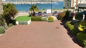A coastal view with a marina, a flagpole with a flag, and a building with a traditional architectural style. - Manoir du Cunningham (Saint-Malo)
