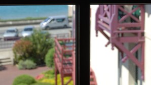 A coastal view with a building featuring a red staircase and a balcony. - Manoir du Cunningham (Saint-Malo)
