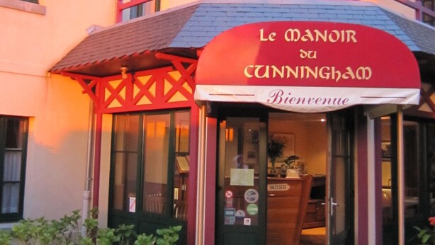 A building with a red awning and a sign that reads "Le Manoir de Cunningham." - Manoir du Cunningham (Saint-Malo)
