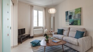 Ein stilvolles Wohnzimmer mit einer Couch, einem Couchtisch und einem Flachbildfernseher.