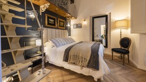 Une chambre à coucher avec un lit, une chaise, un bureau et un escalier.