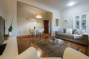 Una sala moderna con una mesa de centro de vidrio, un sofá y un comedor con sillas y una mesa.