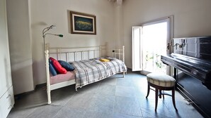 A bedroom with a bed, a piano, a painting, and a window. - Pergola in Palazzo Leopardi (Florence)